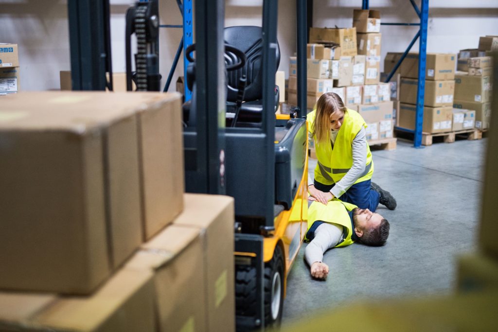 An accident in a warehouse. Woman performing cardiopulmonary resuscitation.